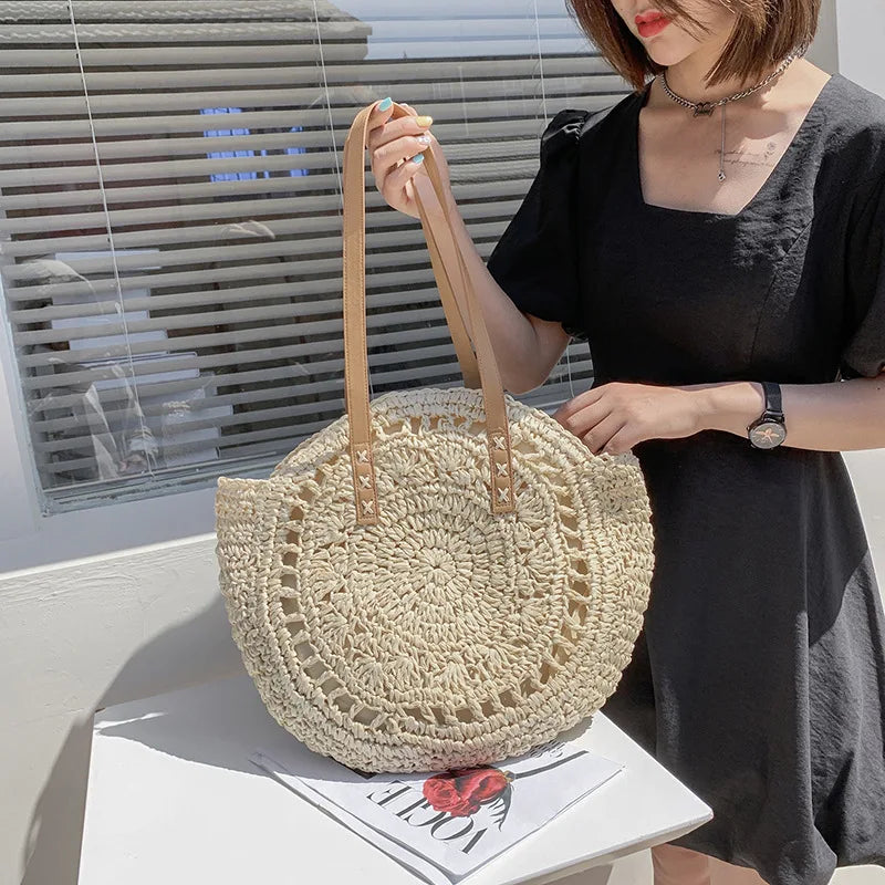 Arnora | Sac rond tressé avec poignées en simili cuir