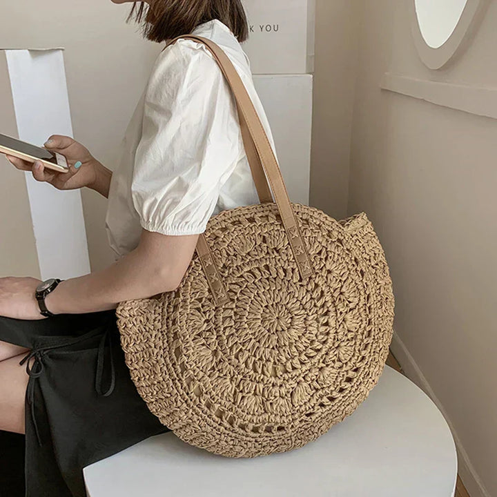 Arnora | Sac rond tressé avec poignées en simili cuir