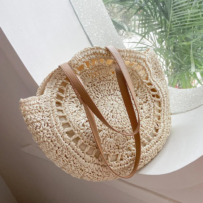 Arnora | Sac rond tressé avec poignées en simili cuir