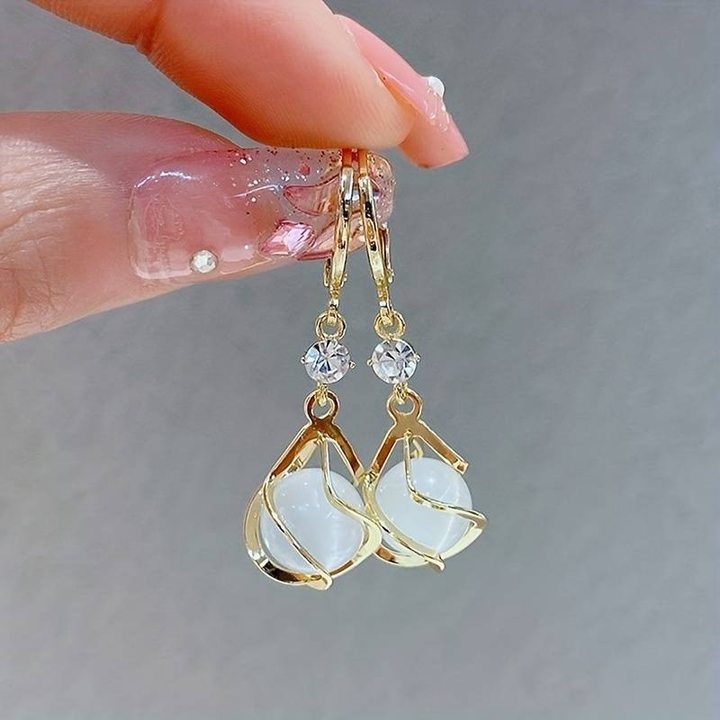 Boucles d'oreilles pendantes en opale blanche enroulées de fil doré